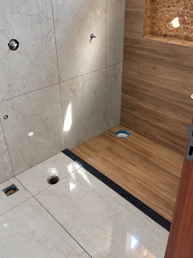 Banheiro com porcelanato marmorizado polido e box em porcelanato amadeirado