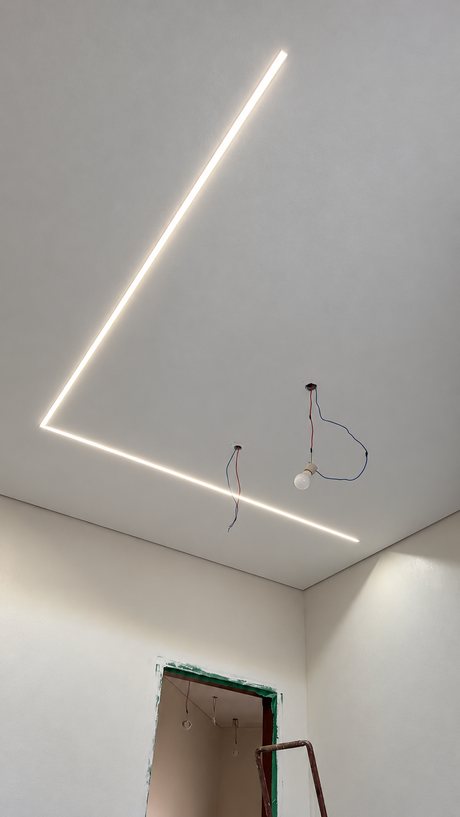 Forro de gesso branco com trilho de LED embutido desenhando um ângulo no teto